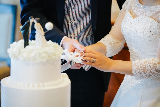 結婚式でケーキに入刀する新郎新婦